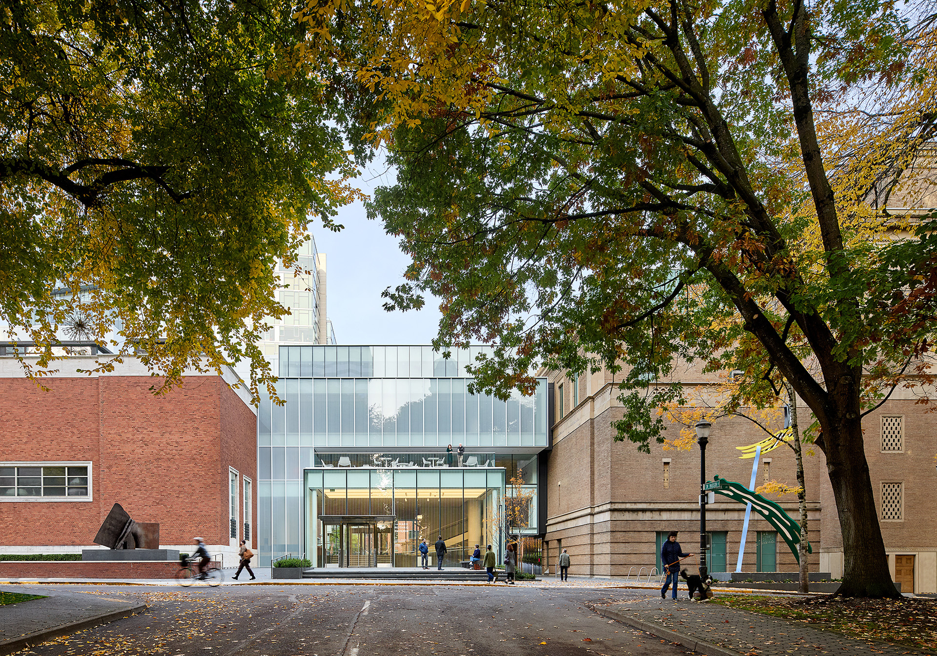Modern glass entrance of the Rothko Pavilion framed by autumn trees, contrasting with the red brick of the adjacent building.